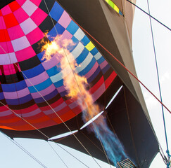 A hot air balloon with a red and orange striped body is floating in the sky