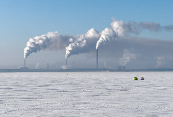 A large industrial plant is spewing smoke into the sky