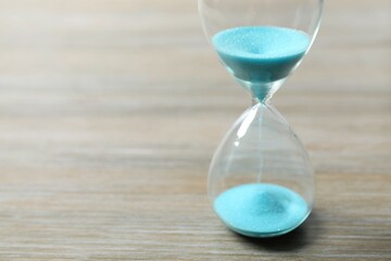 Modern hourglass on wooden background. Hourglass time concept for business deadline, urgency and...