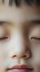 Obraz premium Close-up view of a peaceful child's face with closed eyes, capturing innocence and tranquility.