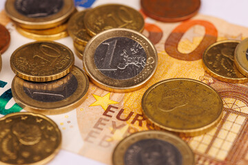 Top View of One Euro Coins and a 50 Euro Banknote on a Bright White Background