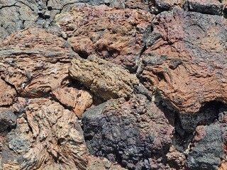 Un assemblage de roches volcaniques aux teintes variées, allant du brun clair au noir profond,...