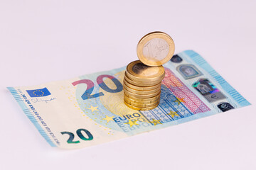 Coins of Euro on 20 Euro Bill with One Coin Standing Tall