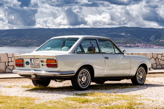Omis, Croatia - August 31st, 2023 - Classical Fiat 124 Sport Coupe on the road. Two-door, four-seater coup&eacute; was based on 124 saloon and its  "Lampredi engine" was designed by ex-Ferrari engineer.