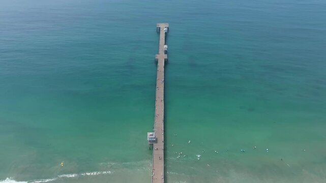 Aerial view of San Clemente pier pulling back to reveal coastline