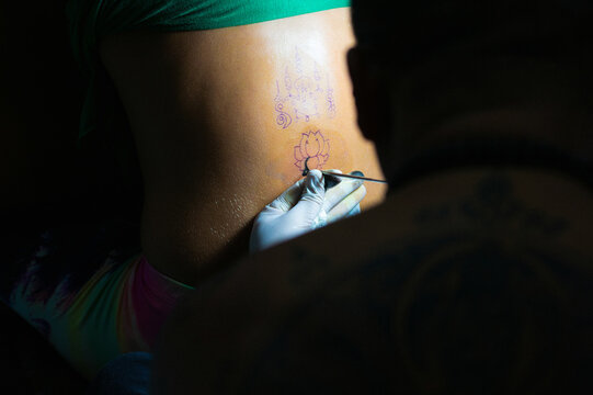 Buddhist monk doing traditional Buddhist Thai Sak Yant tattoo