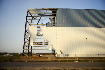 A large, partially collapsed warehouse from hurricane damage