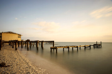 Obraz premium Golden hour casts a warm glow over the hurricane damaged wooden