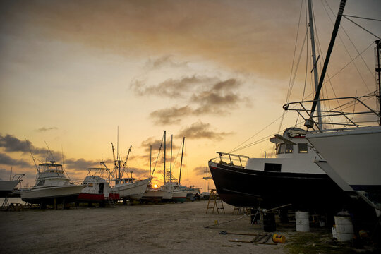 The marina is filled with various boats resting on dry land.