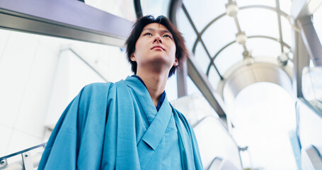 Man, thinking and escalator with traditional clothes, outfit and yukata for heritage. Japanese guy,...