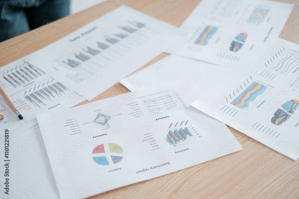 Poster close-up of various business analytics charts and graphs on a wooden desk, showcasing data visualiza