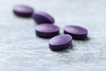 Lutein tablets. Dietary supplement on wooden background. Soft focus. Close up. Copy space	