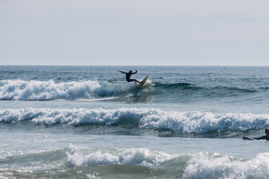 Surfer in portugal mid-action on a wave, splashing water around