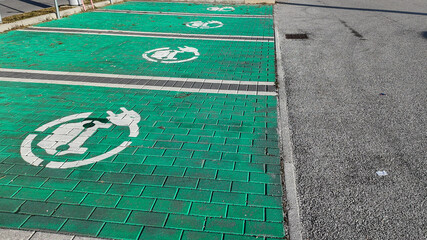 Green parking spaces with electric vehicle charging symbols highlight eco-friendly transportation solutions and sustainable infrastructure concepts