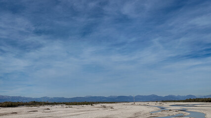 A vast arid landscape under a clear blue sky represents drought and environmental challenges in...