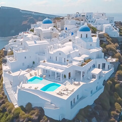 Fototapeta premium aerial view of stunning whitewashed santorini houses with blue domed churches and infinity pool