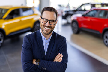 Cropped portrait of a handsome young male car salesman working on the showroom floor. Happy...