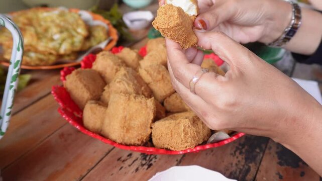 eating together at a tofu restaurant in Sumedang, West Java, Indonesia. Apart from the tofu menu, there are also lontong (sticky rice) and fritters food, serve with sambal or dipping sauce