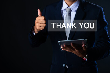 A businessman using his mobile phone and laptop and touching the thank you message on the screen. Thank you, congratulations and appreciation business concept. Presentation of digital technology