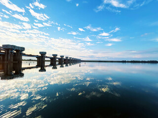 夕刻時の川面に反射する水門と空模様