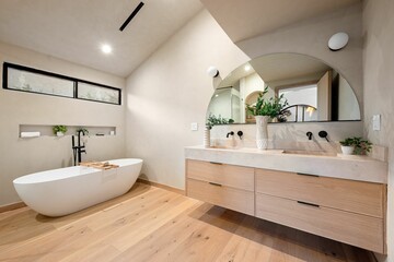 Modern bathroom with freestanding tub and wooden vanity.