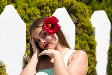 portrait of young and beautiful Latin woman with long blond hair and perfect skin dressed in green,...