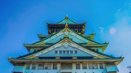 Obraz premium photograph of Osaka's landmark Osaka Castle castle tower that shines in the blue sky