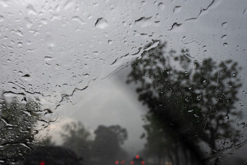Raindrops on the car glass while driving through heavy rain and storm.
