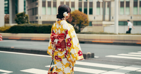 City, walking and woman on crosswalk with kimono, morning commute and sightseeing in traditional clothes. Explore, discover and girl with Japanese fashion, culture or urban street on travel from back