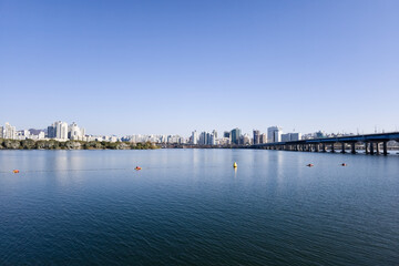 Fototapeta premium panorama view of the river, Yeouido Hangang River Park, in Seoul, Korea, with a broad bridge, and a cityscape in the backdrop