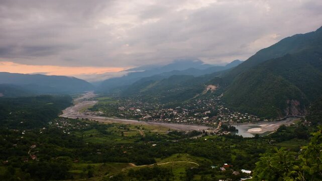 Tsageri, Georgia. Aerial view of a small town Tsageri, Georgia hidden among the mountains. Time-lapse at the sunset with beautiful clowds