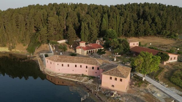An orbiting view of Zvernec Monastery nestled within the tranquil Narta Lagoon in Albania