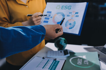 ESG environmental social governance display on laptop on eco-friendly company meeting with business...