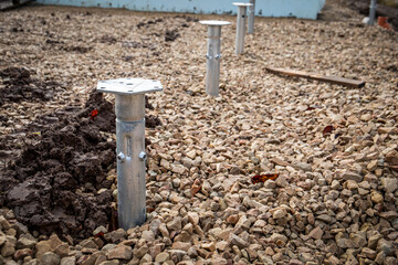 Hot-dip galvanized screw piles screwed into the ground. Abandoned construction