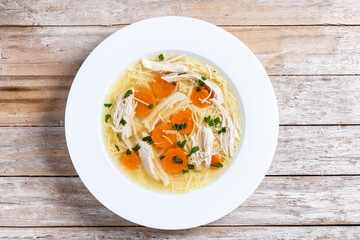 Homemade chicken soup on wooden table