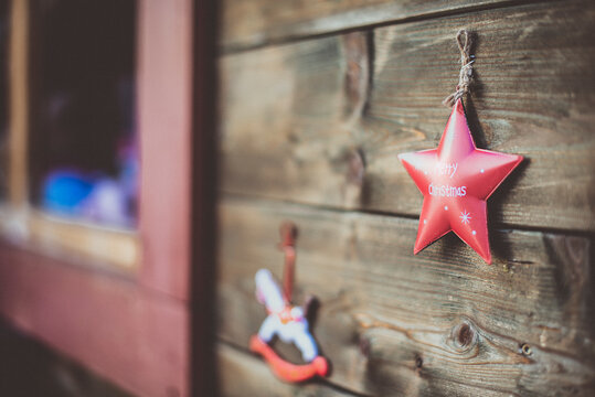 Close-up of a rocking horse and star shaped Christmas ornaments hanging on a wooden stall at a Christmas market, Innsbruck, Tyrol, Austria