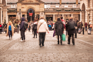 Busy motion blurred shopping street scene