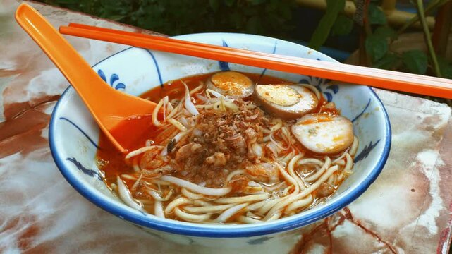 A bowl of hokkien noodle filled with anchovies, egg, bean sprouts in shrimp-based soup. It is very popular in Malaysia and Singapore.