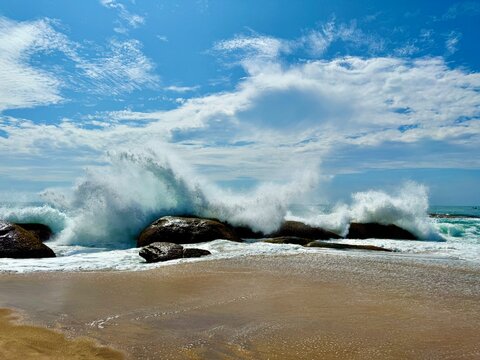 Waves crashing on coastal rocks on a sandy beach in Palatupana (Block 1), Yala, Sri Lanka