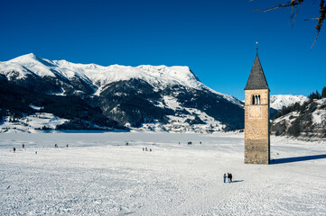 Bell tower of the ancient disappeared village of Curon. Lake Resia in winter.