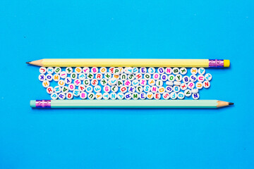 Pencil and English letters placed on blue background, English learning concept
