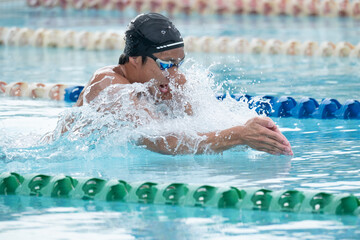 Close-up side view of a man swimming breaststroke in a swimming pool