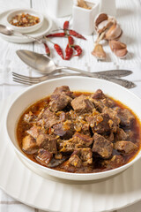 beer braised pork stew in a white bowl