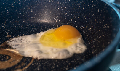 Chicken egg being fried in a pan close-up