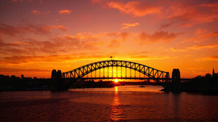 Naklejka premium Sydney Harbour Bridge at sunrise with warm orange skies
