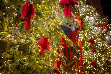 Season's greetings scene. Christmas decorations, balls, rustic star, holly berries, frosty spruce branches, confetti, blur lights on green backdrop, perfect for messages or promo