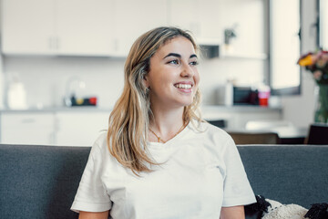 Head shot close up dreamy young smiling beautiful woman looking away, visualizing future indoors of...