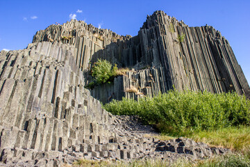 Majestic basalt mountains from which trees grow. Rod-shaped hexagonal stone mountains in the...