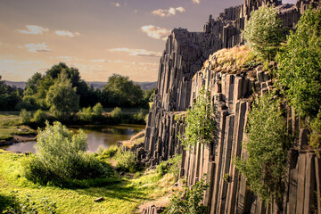 Majestic basalt mountains from which trees grow. Rod-shaped hexagonal stone mountains in the...