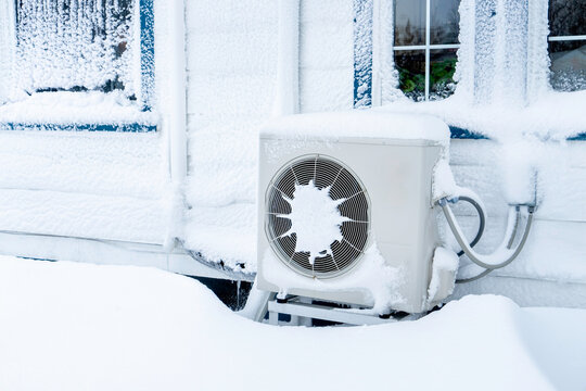 Heat pump in winter on the side of a North American home.